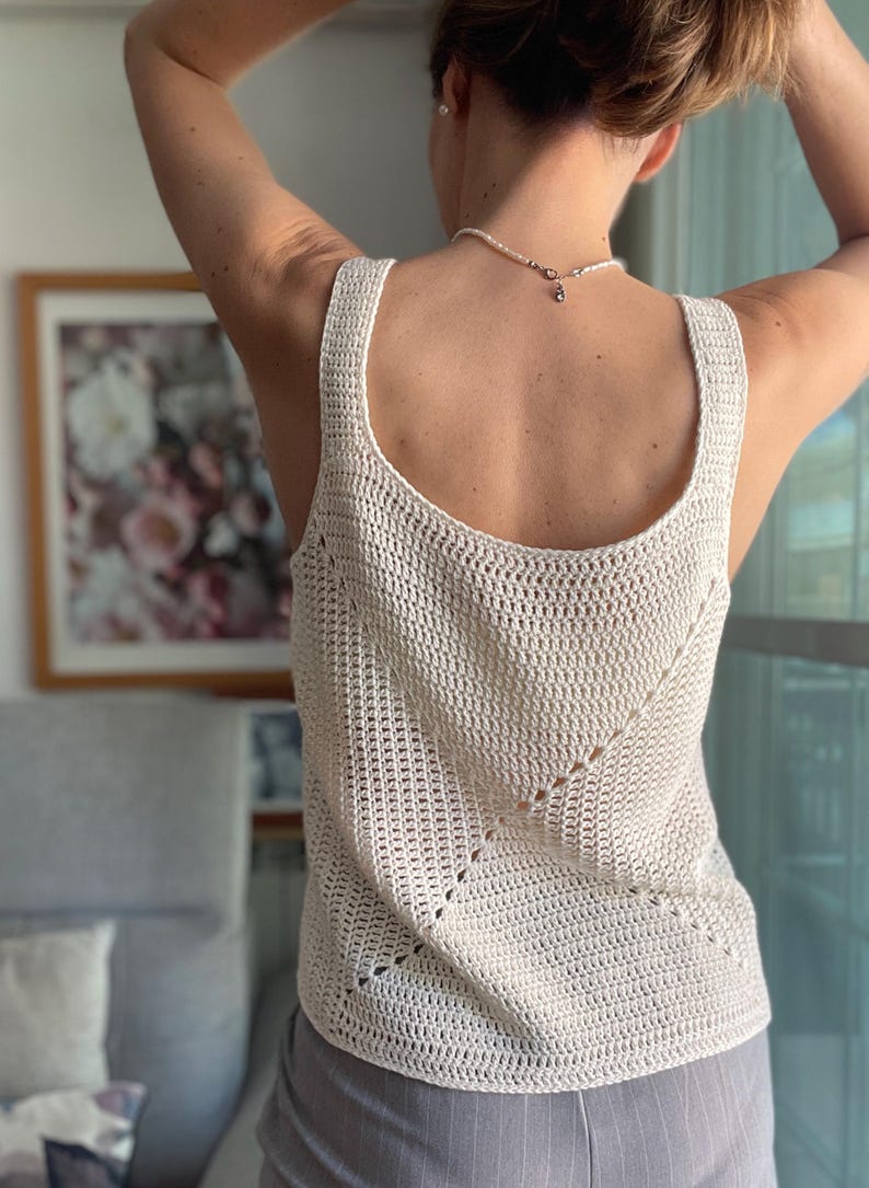 Peut inclure: Un d&eacute;bardeur en crochet blanc avec un motif ajour&eacute; d&eacute;licat. Le d&eacute;bardeur a un col rond et une coupe ample.