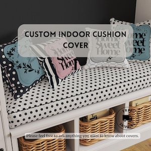 May include: A white bench with black polka dots and a black and white striped cushion. The cushion has three pillows with the text "Home Sweet Home" on them. The bench has three wicker baskets underneath.