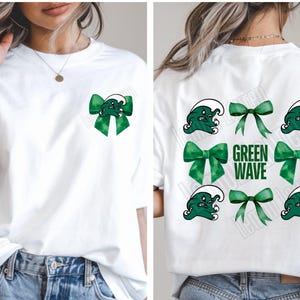 May include: White t-shirt with a green bow and the words "Green Wave" on the front. The back of the shirt has multiple green bows and a green wave graphic.