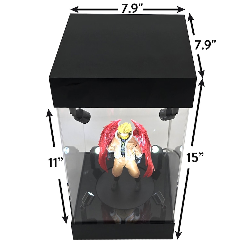 May include: Black display case with a clear front and top, featuring a figurine with red wings. The case is 7.9 inches wide and deep, and 15 inches tall. The interior has spotlights and a black base.