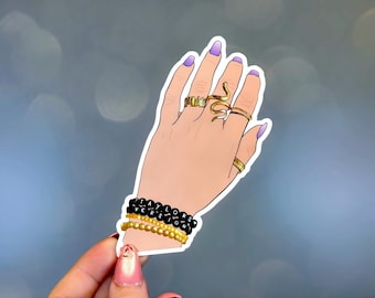 Pegatina de mano con pulsera de la amistad de Taylor Swift, anillos dorados, joyas de serpiente y uñas lavanda. Calcomanía de vinilo estética Swiftie.