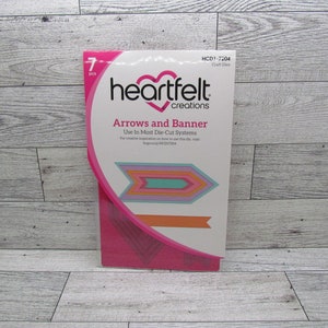 Puede incluir: Un paquete de troqueles artesanales Heartfelt Creations, titulado "Arrows and Banner". El paquete presenta un diseño rosa y blanco con un logotipo de corazón. Los troqueles son multicolores, incluyendo tonos de rosa, naranja y turquesa. El paquete contiene 7 piezas.