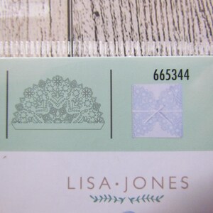 May include: A package with a pale green background featuring a detailed floral design and the text "LISA JONES." The number "665344" is printed on the package. A small square shows a lace design.