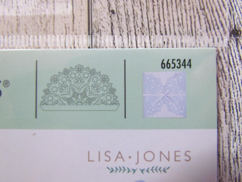 May include: A package with a pale green background featuring a detailed floral design and the text "LISA JONES." The number "665344" is printed on the package. A small square shows a lace design.
