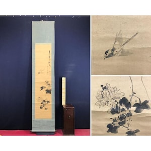 May include: An antique Asian scroll painting with a pale blue border and a central panel featuring a floral and bird design in black ink. A small wooden box and two additional ink paintings of a bird and flowers are also visible.
