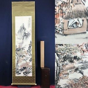 Peut inclure: Une longue peinture sur rouleau asiatique verticale avec une scène de paysage. L'œuvre d'art présente des montagnes, des arbres et un petit bâtiment, rendus en noir, blanc et nuances de gris, avec des touches de rouge et d'or. Le rouleau est encadré en or.