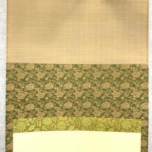 May include: A layered textile sample featuring a beige linen-like top section, followed by a section of olive green fabric with a floral pattern. Below is a strip of lighter green floral fabric, and a cream-colored bottom.