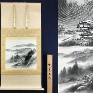 Peut inclure: Un rouleau suspendu japonais traditionnel avec une peinture à l'encre monochrome d'un paysage de montagne avec des maisons. Le rouleau a un fond crème et des accents dorés. Un bâton en bois avec des caractères japonais est à droite.