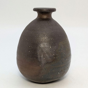 Peut inclure: Un vase en céramique brun foncé fait à la main, avec un corps arrondi et un col étroit. Le vase a une texture tachetée et une finition mate, mettant en valeur une esthétique rustique. Le récipient convient pour exposer des fleurs ou comme élément décoratif.