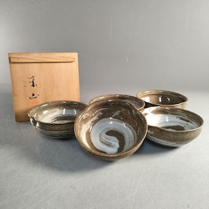 May include: A set of five ceramic bowls with a brown and white swirl design. The bowls have a rustic appearance and are displayed with a wooden box. The bowls are suitable for serving food.