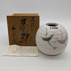 May include: A spherical ceramic vase with a textured surface and a small opening, decorated with bird motifs in grey and pink. It is presented with a wooden box bearing Japanese calligraphy and a paper document.