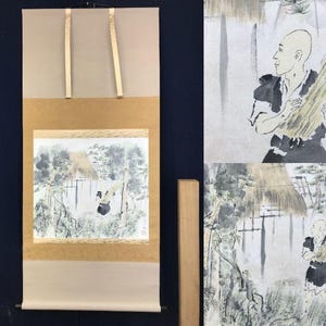 May include: Japanese scroll painting depicting a landscape scene with a figure carrying wheat. The artwork uses muted tones of beige, grey, and black, focusing on the natural environment and a traditional aesthetic. The scroll is displayed with its original hanging cords.
