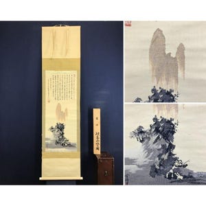May include: A vertical hanging scroll featuring a landscape painting with a mountain and dark rock formations on a light background. The scroll includes columns of Japanese calligraphy text and a wooden storage box with matching Japanese characters.