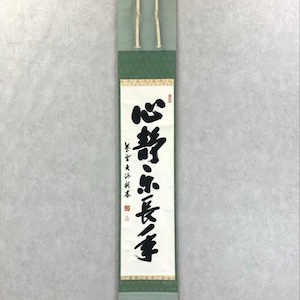 Puede incluir: Un rollo japon&eacute;s vertical con caligraf&iacute;a negra. El rollo tiene bordes verde claro y verde oscuro, con una secci&oacute;n central de color crema. El texto est&aacute; escrito en un estilo tradicional de Asia Oriental.