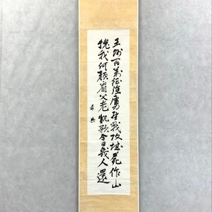 Op de afbeelding: Een traditionele Japanse rol met zwarte kalligrafie op een crèmekleurige achtergrond. De rechthoekige rol heeft een houten balk aan de onderkant en een ophangketting aan de bovenkant. De verticale tekst lijkt een gedicht of gezegde te zijn.