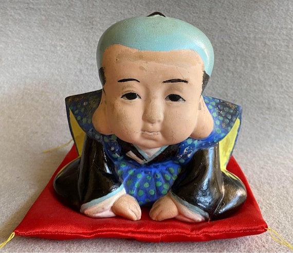 福助縁起物置物（赤い座布団付き） – 繁栄と幸運を祈願する日本の伝統