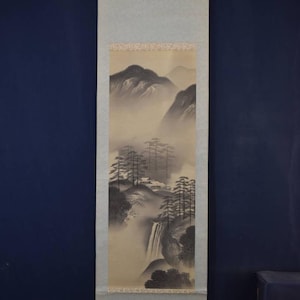 Könnte beinhalten: Vertikales Rollbild, das eine neblige Berglandschaft mit Wasserfall und Bäumen zeigt. Das Kunstwerk ist hauptsächlich in Grau- und Beigetönen gehalten, mit einer detaillierten Darstellung der Natur.