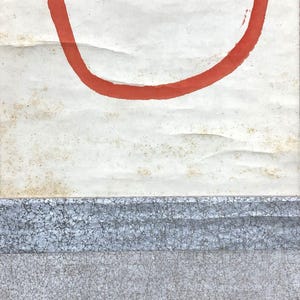 May include: Abstract artwork featuring a large, curved red line against a textured, off-white background. The lower portion displays a textured, gray and blue horizontal band. The piece has a minimalist aesthetic.