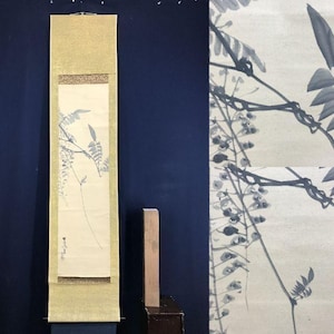 Op de afbeelding: Een Japans rolschilderij in verticale stand, met een monochrome inktwasillustratie van bladeren en takken. Het kunstwerk heeft een gouden rand en een donkerblauwe achtergrond. De schildering is ongeveer 100 cm lang.