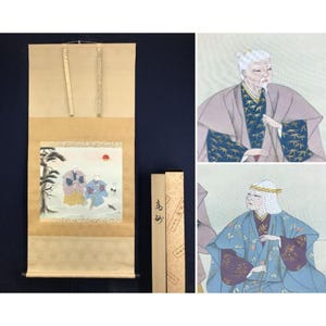 May include: Japanese scroll painting depicting two figures in traditional dress, a tree, and a red sun. The scroll is beige with a dark blue backdrop. The painting is in a rectangular frame. A box with Japanese text accompanies the scroll.