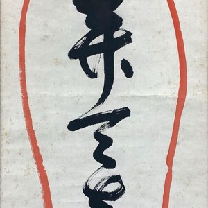 May include: A close-up of a piece of art featuring black calligraphy on a white background. The calligraphy is enclosed within a red oval border. The paper has a slightly aged appearance.