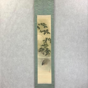 Könnte beinhalten: Vertikales japanisches Rollbild mit zwei Fischen, die unter einem Ast schwimmen. Das Kunstwerk ist von einem hellgrünen Rand und einem strukturierten oberen Abschnitt umrahmt. Die Schriftrolle wird von einer Metallstange gehalten.