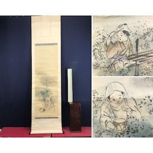 May include: An antique Japanese scroll painting with a landscape scene, displayed next to a wooden box and a white rectangular object. Two watercolour paintings depict figures in a field, possibly harvesting.