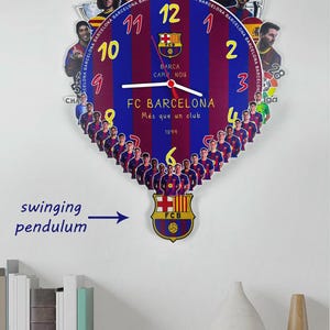 May include: A wall clock featuring the FC Barcelona team logo and colors, with a pendulum. The clock face has the team's logo, player images, and the words "FC Barcelona". The clock is red, blue, and yellow.