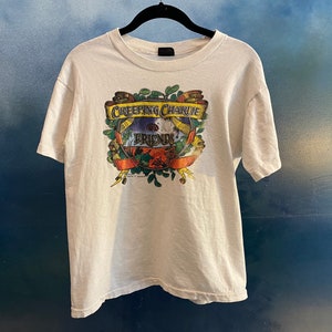 May include: White t-shirt with a graphic print of a band called "Creeping Charlie and the Friends".