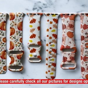 May include: Five different Apple Watch bands with autumn-themed designs. The bands are white with orange and brown pumpkins, leaves, and other autumn-themed patterns.