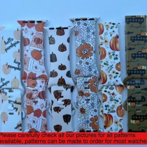 May include: Five different watch straps with autumn-themed patterns. The straps are white with various designs including pumpkins, sunflowers, and a truck with pumpkins. The text "hello pumpkin", "hey pumpkin", and "do pumpkin" are visible on one of the straps.