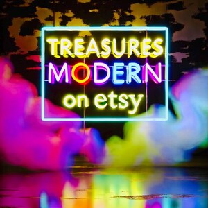 May include: Neon sign with the text "TREASURES MODERN on etsy" in a rainbow of colors against a dark background.