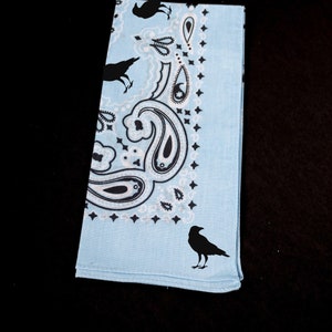 May include: A light blue bandana with a paisley pattern and black crow silhouettes.