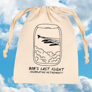May include: Cream-colored drawstring bag with a black illustration of an airplane wing viewed from a window, with clouds below. Text reads "BOB'S LAST FLIGHT CELEBRATING RETIREMENT!"