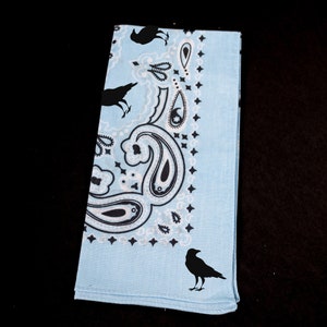 May include: A light blue bandana with a paisley pattern and black crow silhouettes.