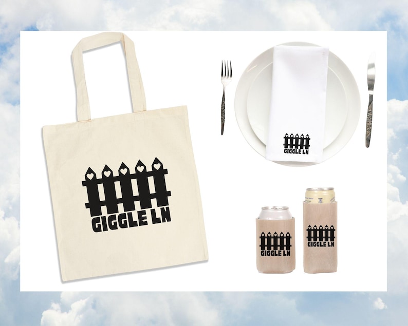 Puede incluir: Colecci&oacute;n de art&iacute;culos con un dise&ntilde;o de valla negra y el texto "GIGGLE LN" en una bolsa de mano color crema, una servilleta blanca sobre un plato y dos enfriadores de latas. Un tenedor y un cuchillo est&aacute;n a cada lado del plato.