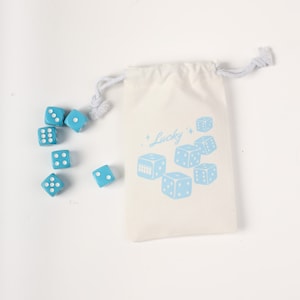 May include: A set of blue dice with white dots, in a white drawstring bag with the word "Lucky" printed on it.