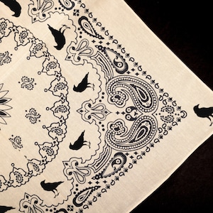 May include: A beige bandana with a black paisley pattern and black crow silhouettes.