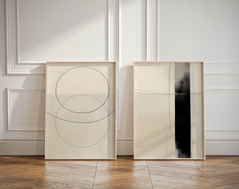 Op de afbeelding: Twee ingelijste abstracte kunstprints met minimalistische ontwerpen. De print aan de linkerkant heeft twee overlappende cirkels in zwart op een crème achtergrond. De print aan de rechterkant heeft een zwarte verticale lijn met een dunne zwarte lijn over de bovenkant op een crème achtergrond.