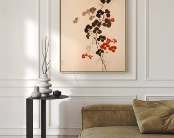 Puede incluir: Una impresión floral en blanco y negro enmarcada con flores rojas sobre un fondo beige. La impresión está colgada en una pared blanca sobre una mesa auxiliar negra con un jarrón y otros elementos decorativos.