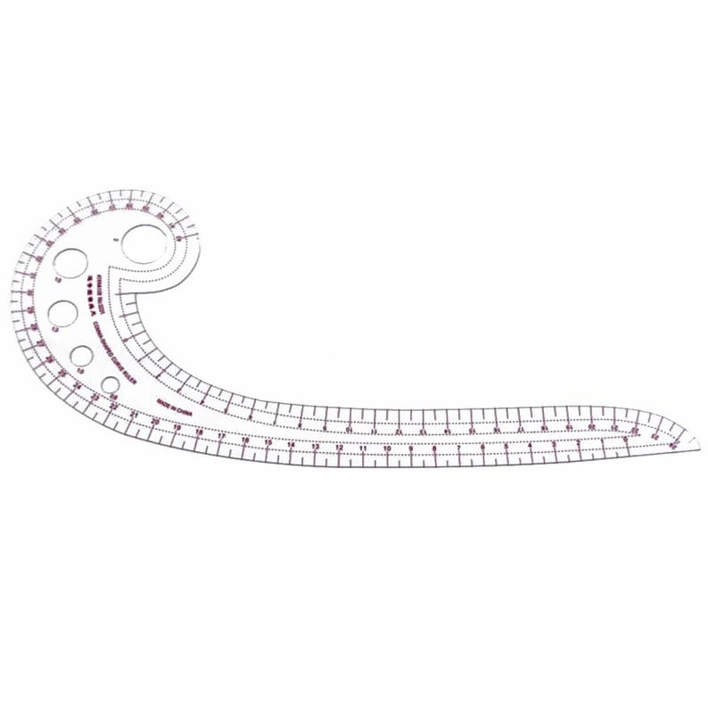 May include: A clear, plastic sewing curve ruler with a curved shape and a straight edge. The ruler has measurements in inches and features several circular cutouts. The text "MADE IN CHINA" is visible.