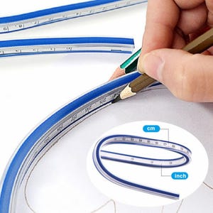 Può includere: Righello curvo flessibile blu e trasparente con segni in centimetri e pollici. Una mano usa una matita per tracciare una curva. Il righello viene utilizzato per disegnare linee e forme curve. Il righello è realizzato in materiale flessibile.
