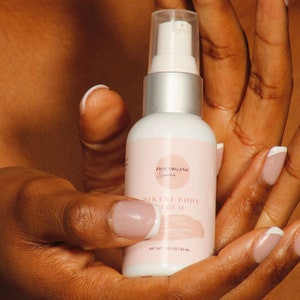 May include: A white bottle with a silver pump top and a pink label that says "Zion Organic Essentials Bikini Body Serum" and "Net Wt. 2 fl oz/59 ml".