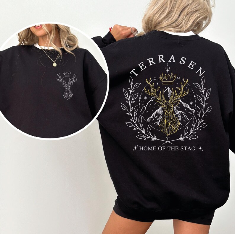 A woman wearing a black sweatshirt with a graphic design on the back.