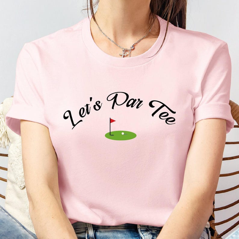 a woman sitting in a chair wearing a pink shirt