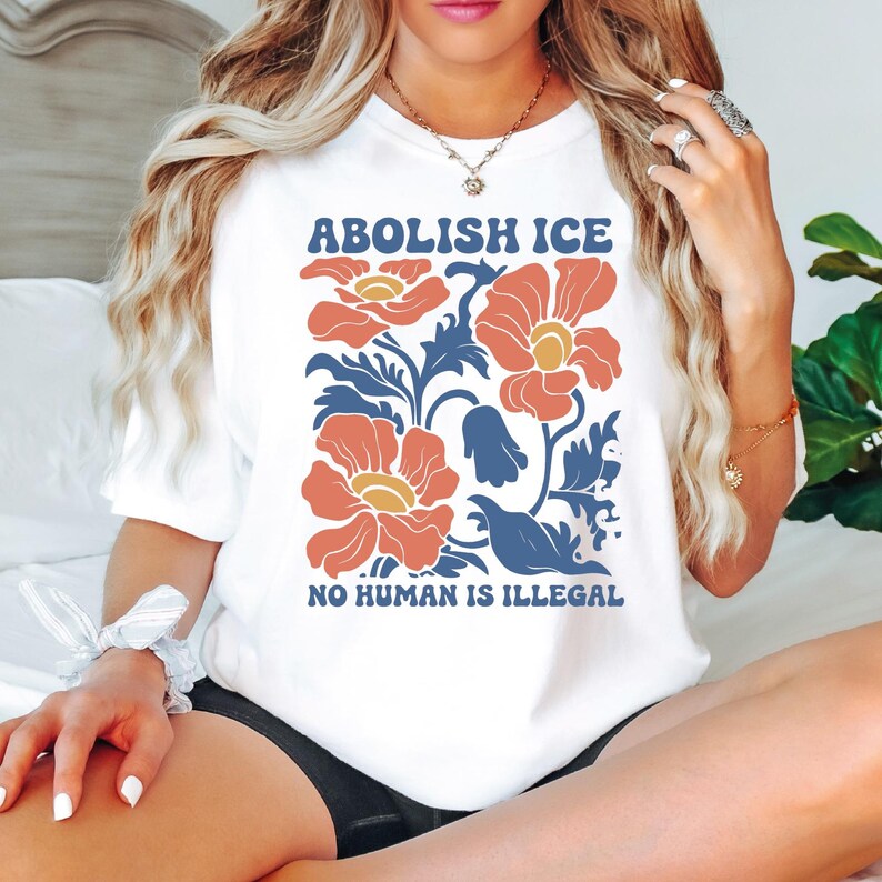 a woman sitting on top of a bed wearing a white shirt