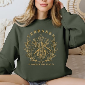 a woman sitting on a couch wearing a sweatshirt