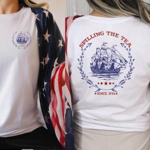 two women wearing matching shirts with a flag