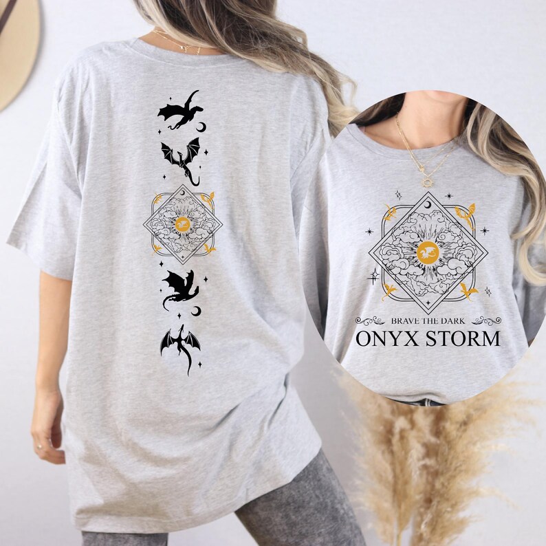 a woman wearing a grey t - shirt with a design on it