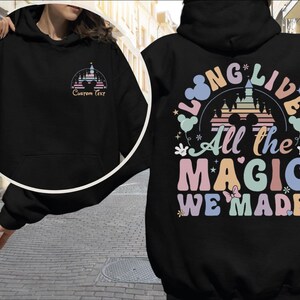 A person wearing a black hoodie with a colorful graphic design on the back.